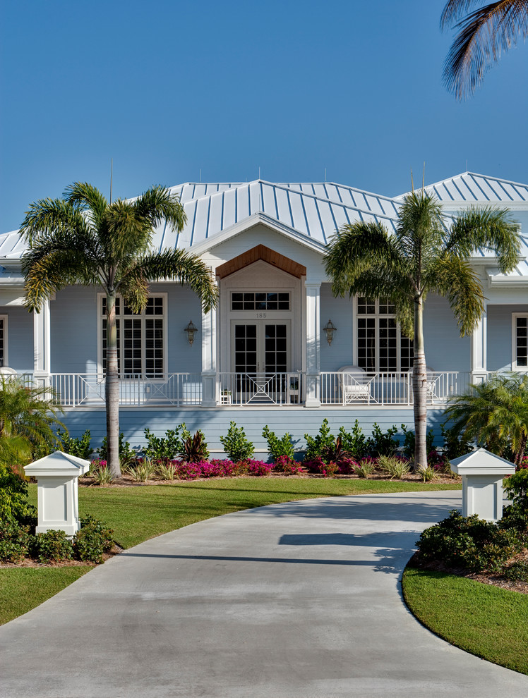 Cette photo montre une façade de maison bleue chic en planches et couvre-joints et brique de plain-pied et de taille moyenne avec un toit à deux pans, un toit en shingle et un toit bleu.