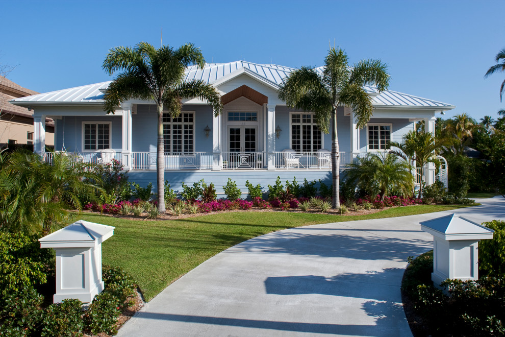 Example of a beach style blue one-story house exterior design in Other with a hip roof and a metal roof