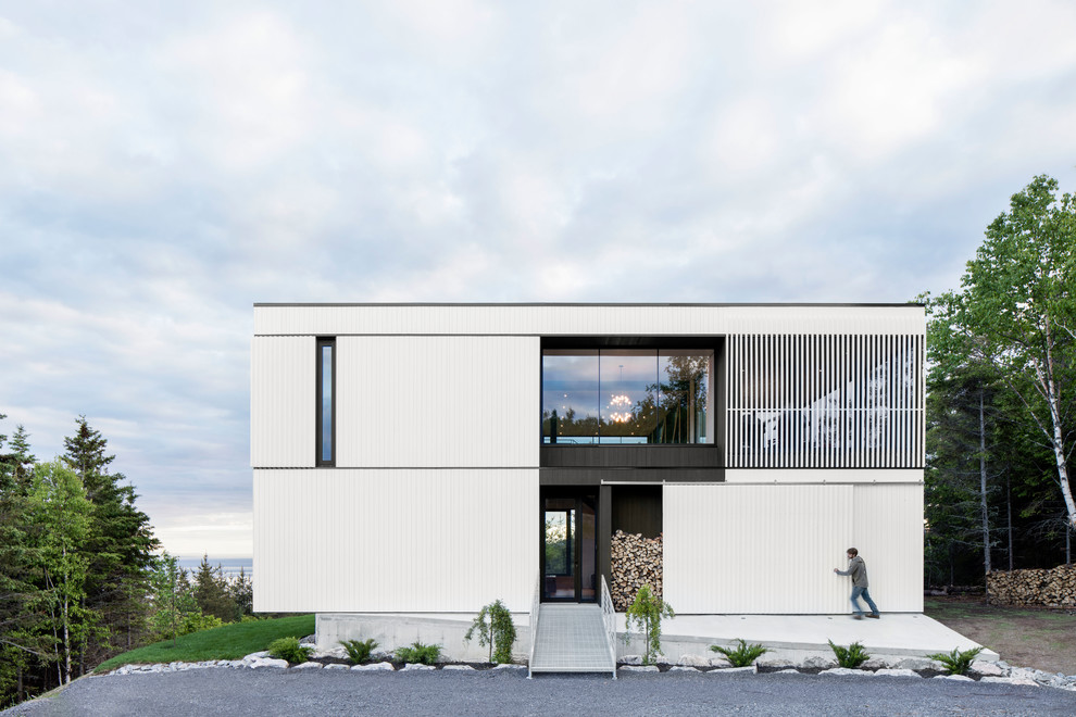 На фото: двухэтажный, белый дом в стиле модернизм с плоской крышей с