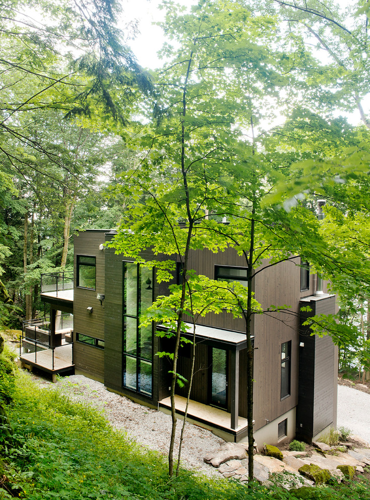 This is an example of a medium sized contemporary house exterior in Montreal with three floors and wood cladding.