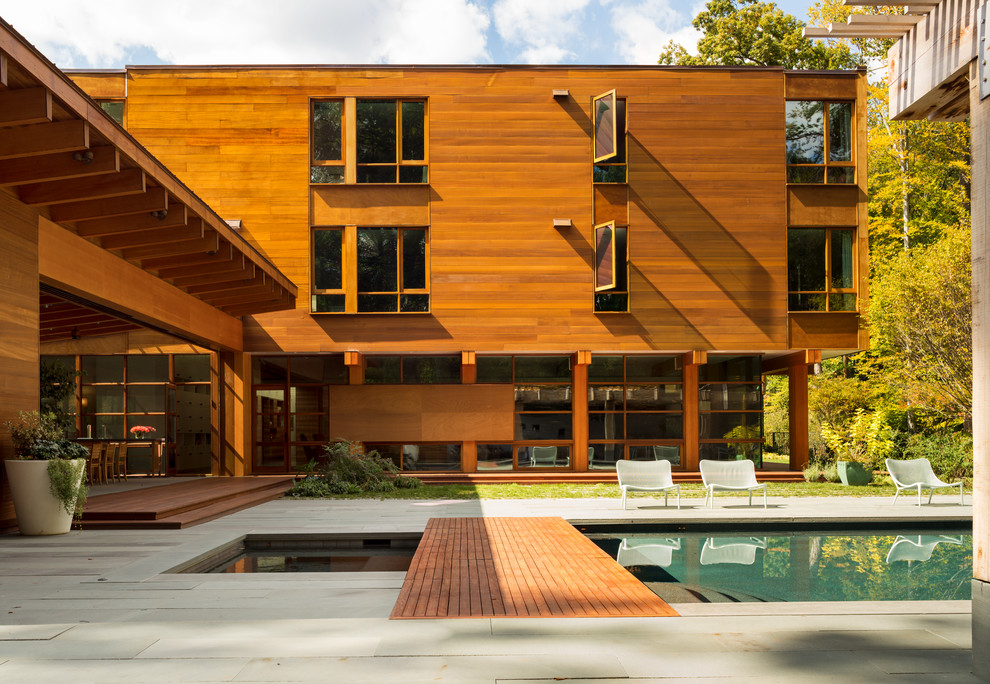 Diseño de fachada minimalista grande de tres plantas con revestimiento de madera y tejado plano