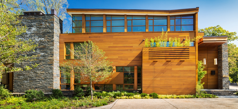 Exemple d'une façade de maison moderne en bois à deux étages et plus avec un toit plat.