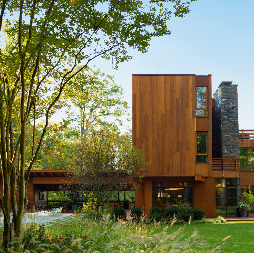 Inspiration pour une très grande façade de maison marron design en bois à deux étages et plus avec un toit plat.