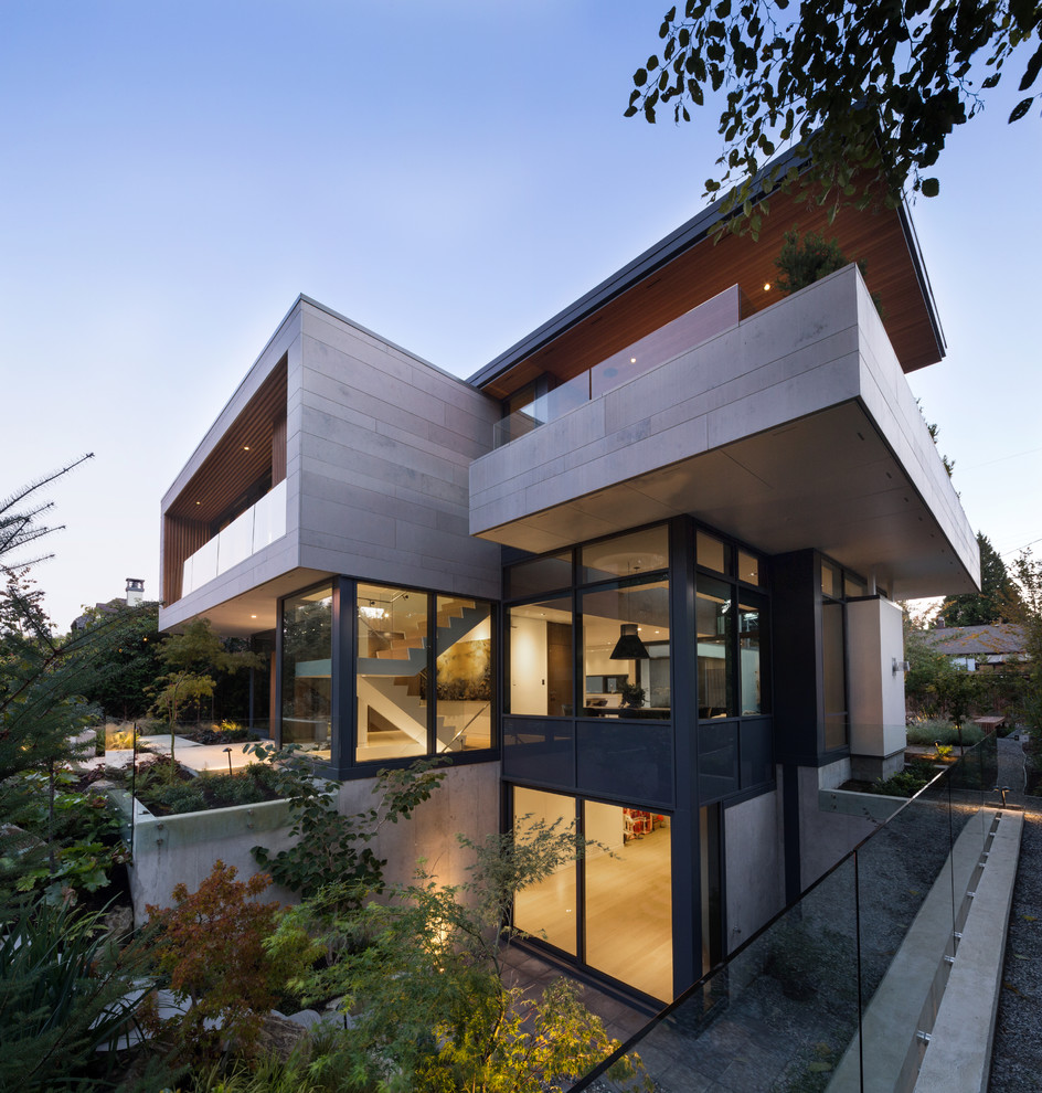 Exemple d'une façade de maison grise tendance en pierre de taille moyenne et à deux étages et plus avec un toit plat.