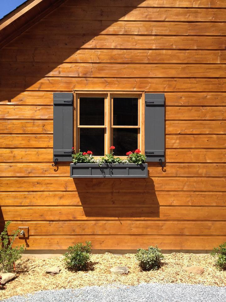 Foto della facciata di una casa marrone rustica a un piano di medie dimensioni con rivestimento in legno