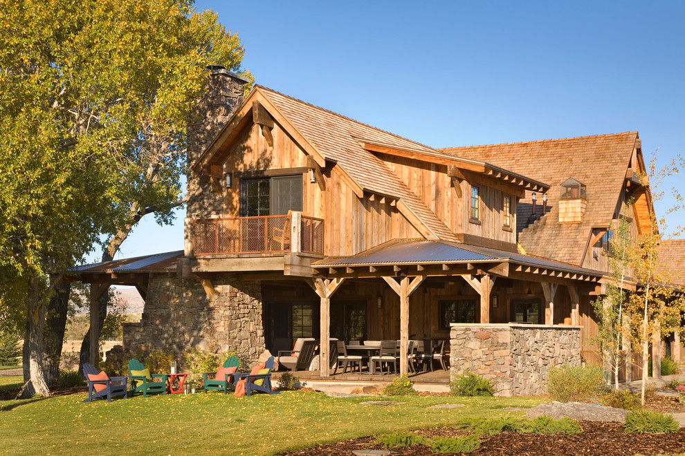 На фото: деревянный, двухэтажный, коричневый дом среднего размера в стиле рустика с односкатной крышей с