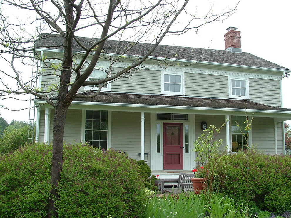 Imagen de fachada gris clásica de dos plantas con revestimiento de madera y tejado a dos aguas