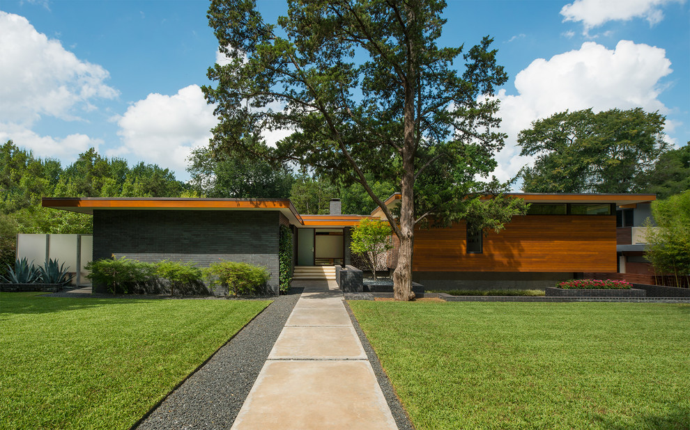 Mid-century modern multicolored one-story mixed siding house exterior photo in Dallas with a shed roof