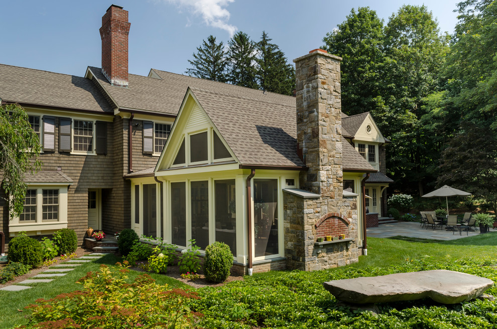 Immagine della facciata di una casa grande marrone classica a due piani con rivestimento in legno e tetto a capanna