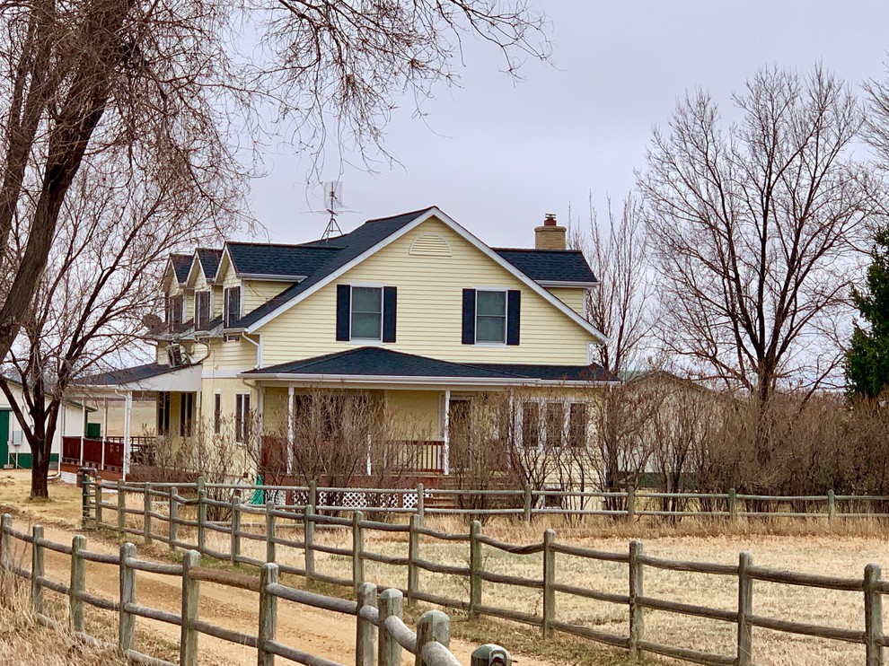 Mittelgroßes, Zweistöckiges Landhausstil Einfamilienhaus mit gelber Fassadenfarbe, Satteldach und Schindeldach in Denver