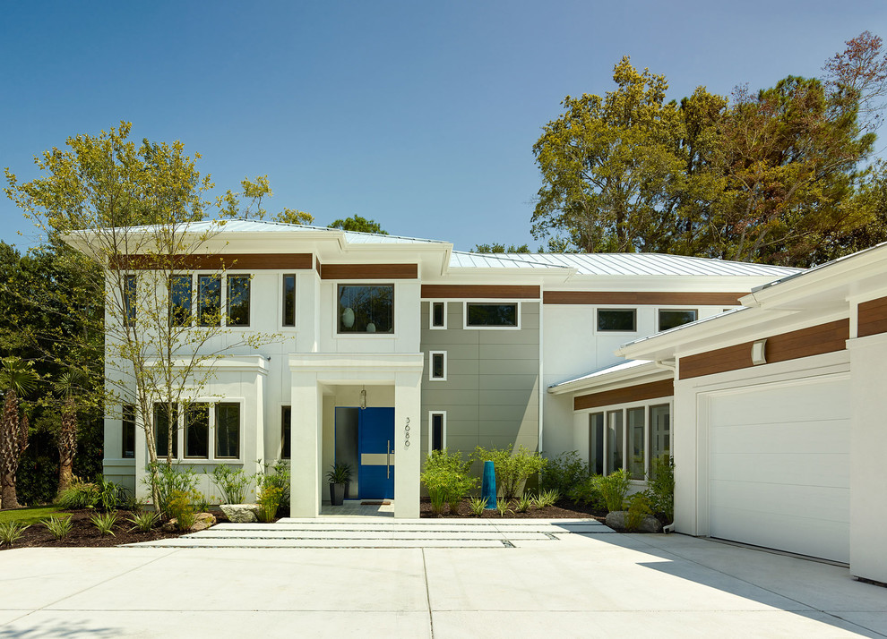 На фото: двухэтажный, белый дом в современном стиле с комбинированной облицовкой и вальмовой крышей с