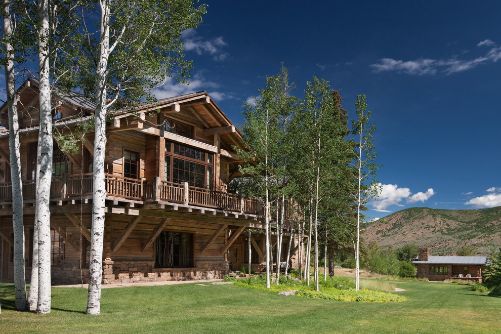 Idées déco pour une façade de maison montagne à deux étages et plus avec un revêtement mixte, un toit à deux pans et un toit mixte.