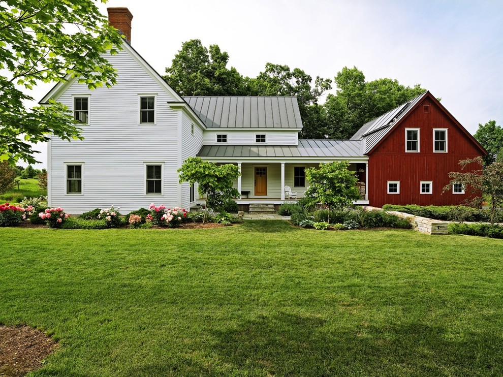 Пример оригинального дизайна: двухэтажный, деревянный, разноцветный частный загородный дом среднего размера в стиле кантри с двускатной крышей и металлической крышей