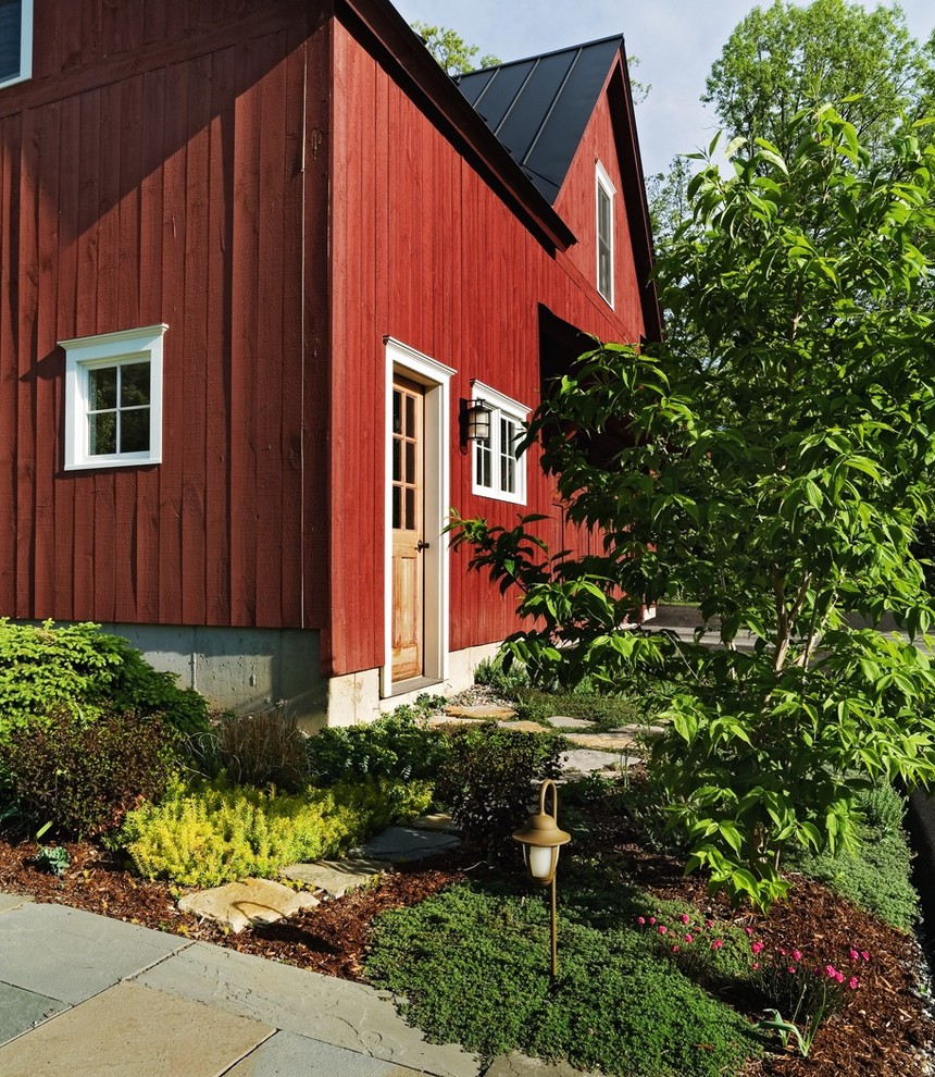Cette photo montre une façade de maison multicolore chic en bois de taille moyenne et à un étage avec un toit à deux pans et un toit en métal.