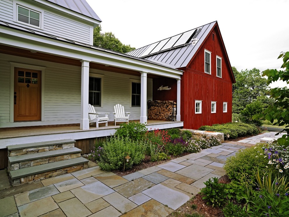 Réalisation d'une façade de maison multicolore tradition en bois de taille moyenne et à un étage avec un toit à deux pans et un toit en métal.