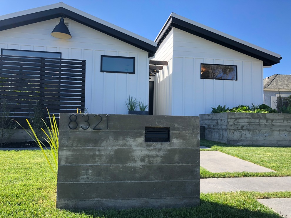 This is an example of a medium sized and white rural bungalow detached house in Los Angeles with concrete fibreboard cladding, a lean-to roof and a metal roof.