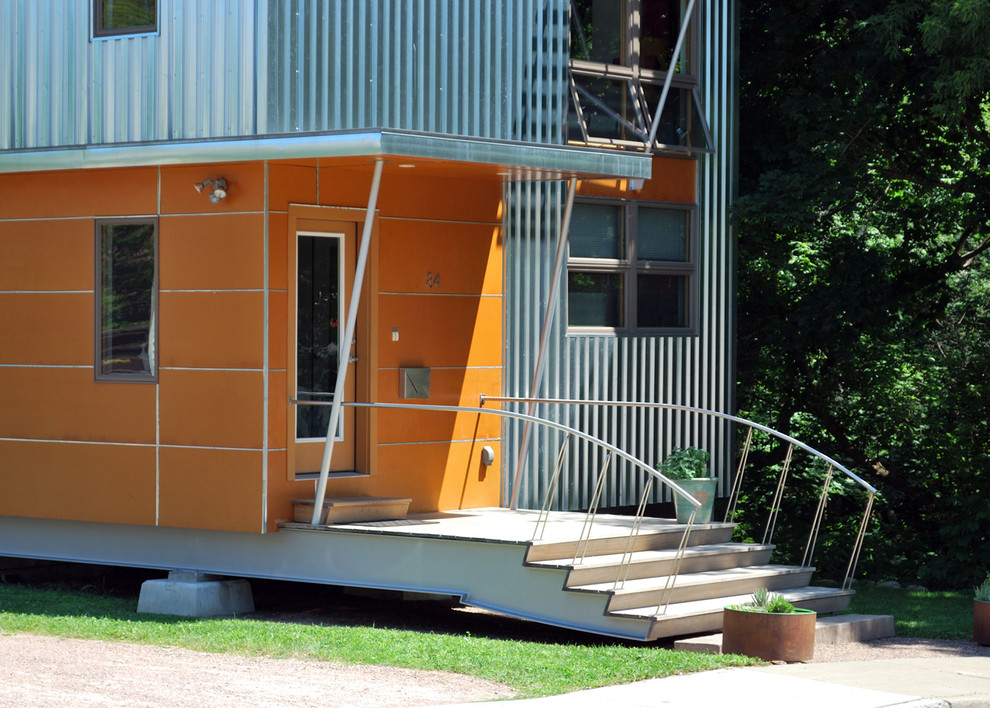 Réalisation d'une façade de maison orange design avec un revêtement mixte.