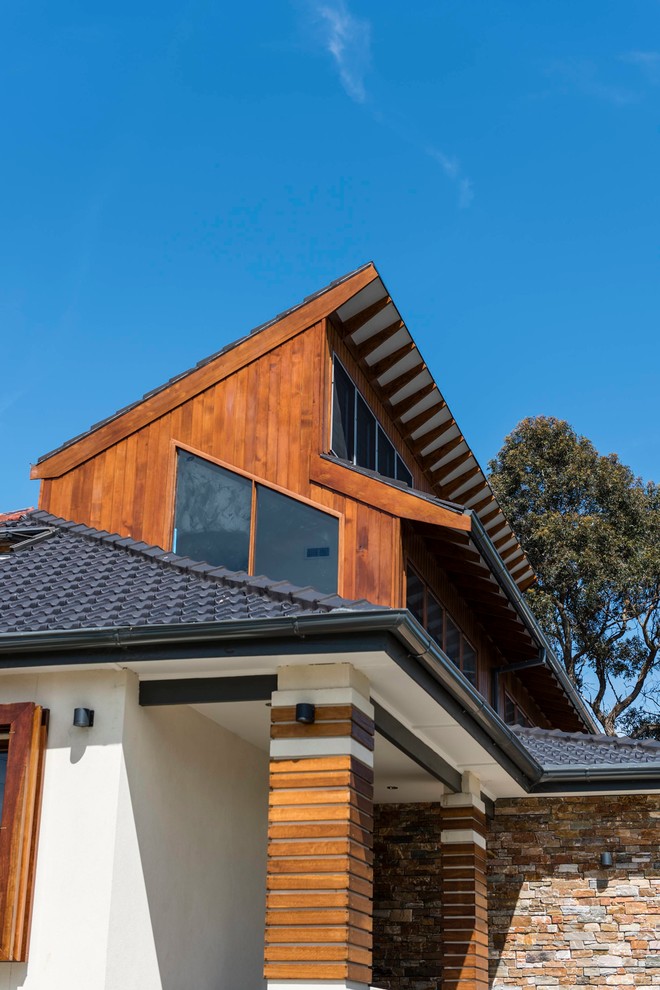 Diseño de fachada de casa marrón moderna de tamaño medio de dos plantas con revestimientos combinados