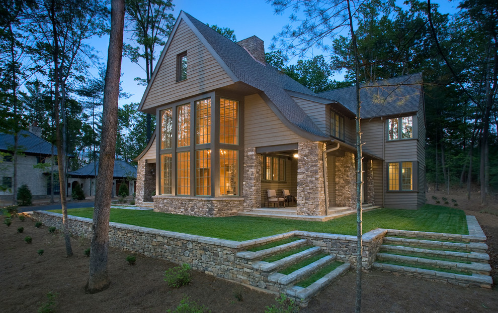 Diseño de fachada de casa marrón clásica grande de dos plantas con revestimiento de piedra, tejado a doble faldón y tejado de teja de madera