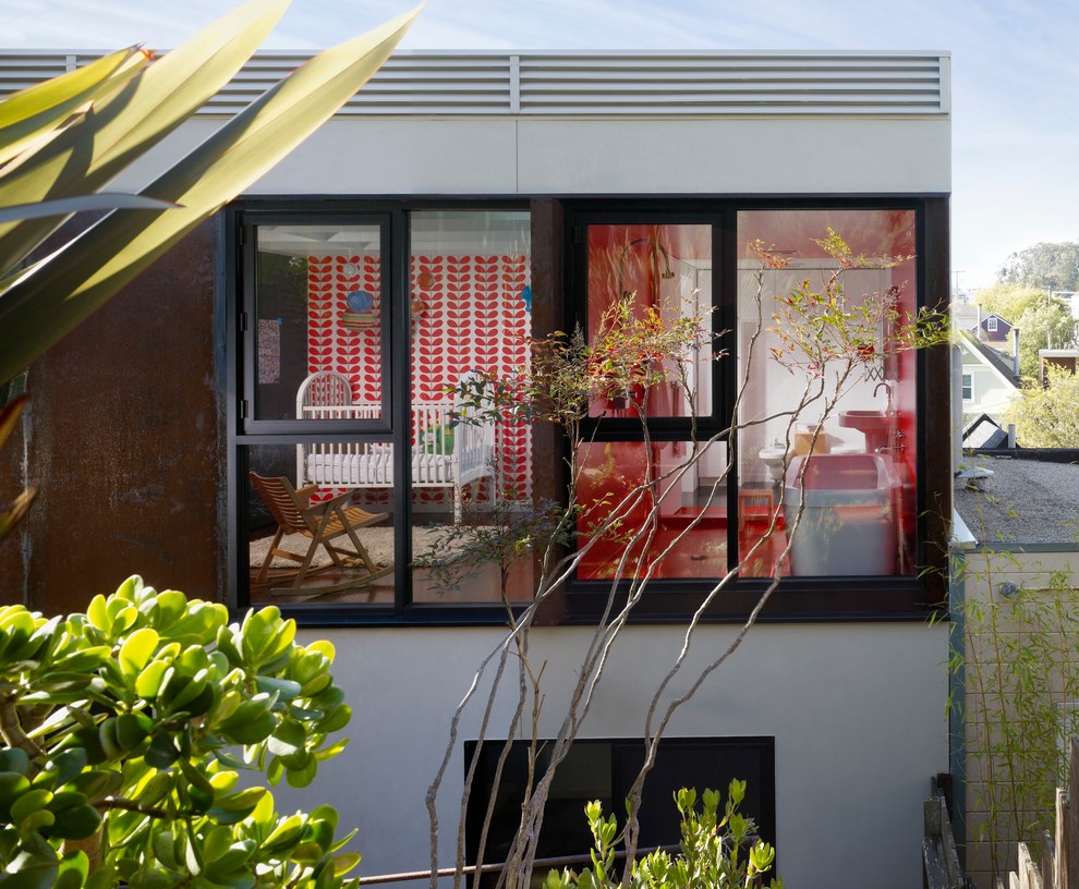 Modelo de fachada beige moderna de tamaño medio de dos plantas con revestimiento de metal y tejado plano