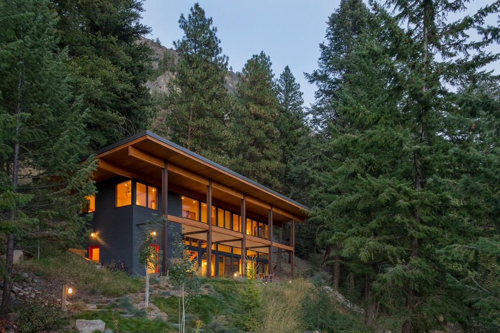 На фото: двухэтажный, деревянный, серый, большой частный загородный дом в стиле рустика с односкатной крышей
