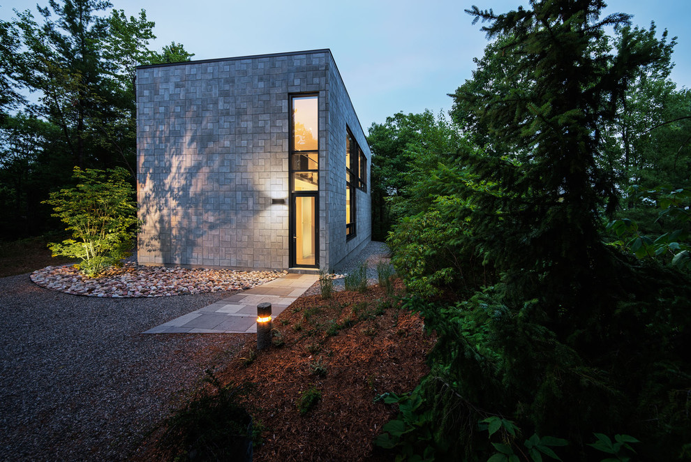 Inspiration for a small modern house exterior in Montreal with stone cladding.