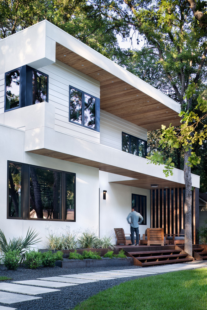 Large minimalist white two-story concrete exterior home photo in Austin with a mixed material roof