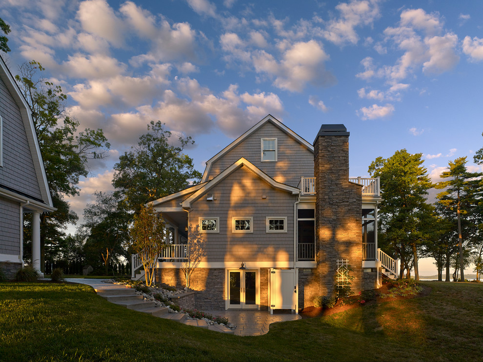 На фото: большой, двухэтажный, деревянный, серый частный загородный дом в классическом стиле с мансардной крышей и крышей из гибкой черепицы с