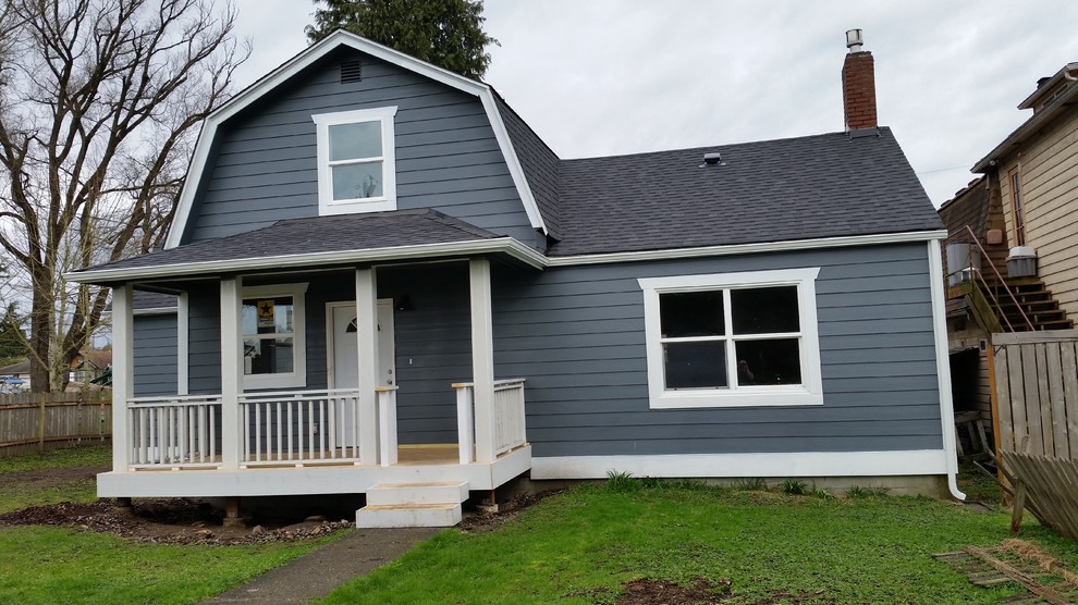 Ejemplo de fachada de casa azul de estilo de casa de campo de tamaño medio de dos plantas con revestimiento de madera, tejado a doble faldón y tejado de teja de madera