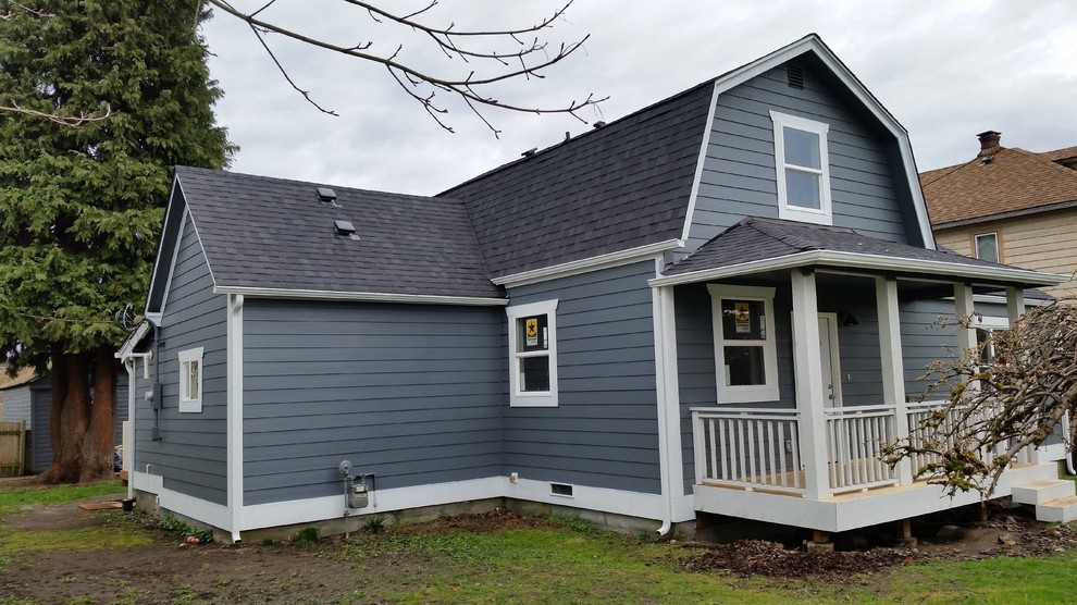 Medium sized and blue country two floor detached house in Seattle with wood cladding, a mansard roof and a shingle roof.