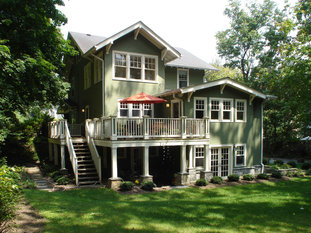 Esempio della villa grande verde american style a due piani con rivestimento in stucco e copertura a scandole