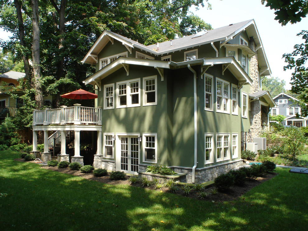 Esempio della villa grande verde american style a due piani con rivestimento in stucco e copertura a scandole