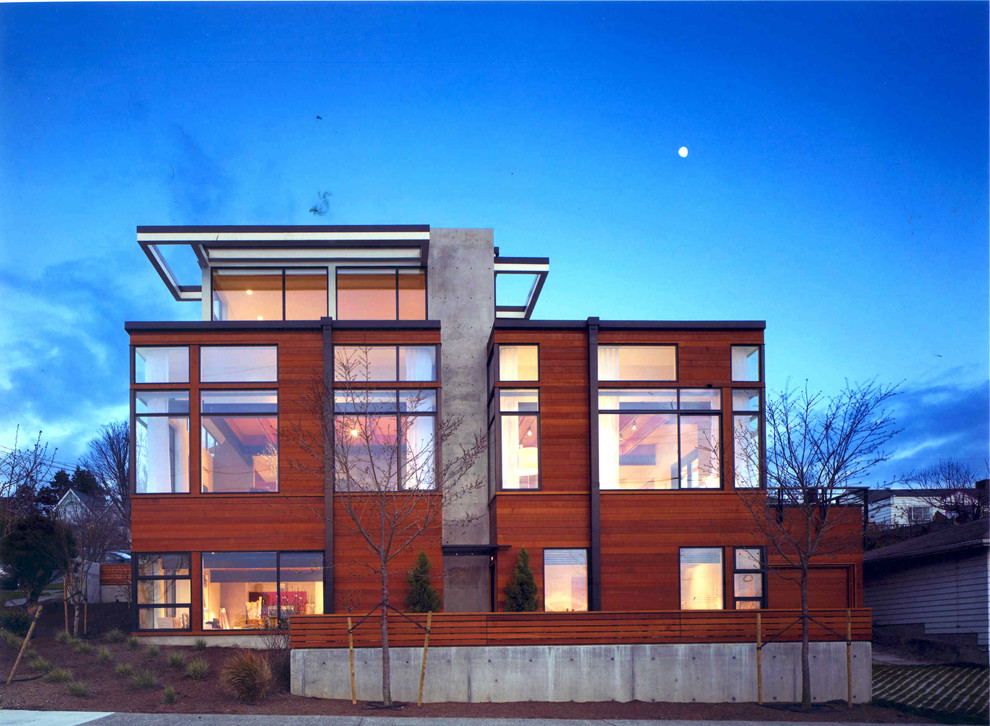 Cette photo montre une très grande façade de maison marron moderne à deux étages et plus avec un revêtement mixte, un toit plat et un toit en métal.