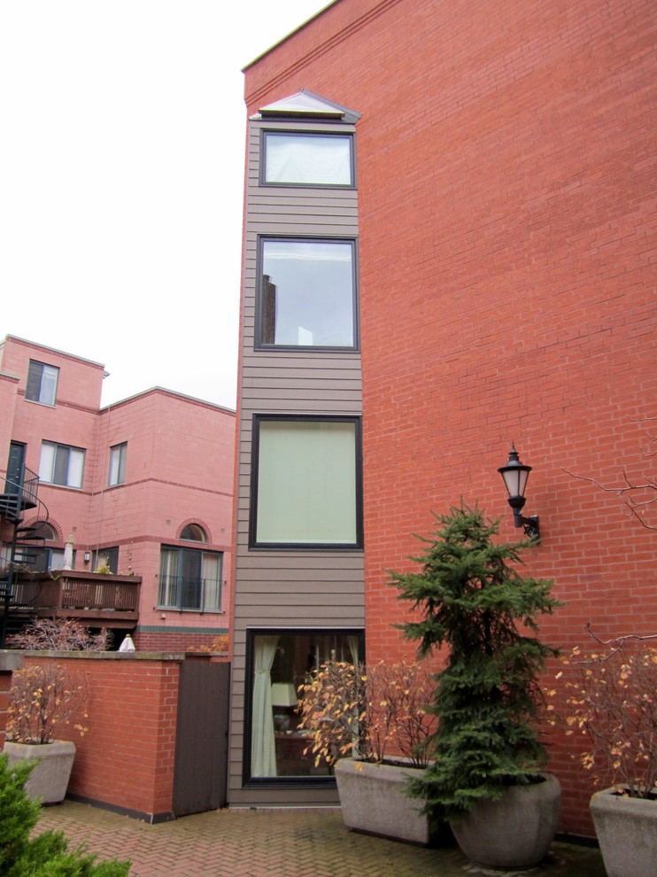 Immagine della facciata di una casa grande marrone moderna a tre piani con rivestimenti misti