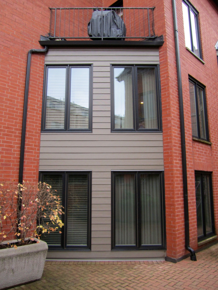 Стильный дизайн: большой, трехэтажный, коричневый дом в стиле модернизм с комбинированной облицовкой - последний тренд