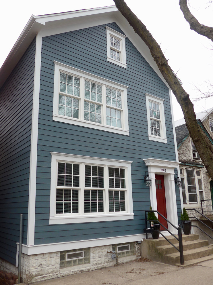 Ejemplo de fachada de casa azul clásica de tamaño medio de dos plantas con revestimiento de aglomerado de cemento y tejado de teja de madera
