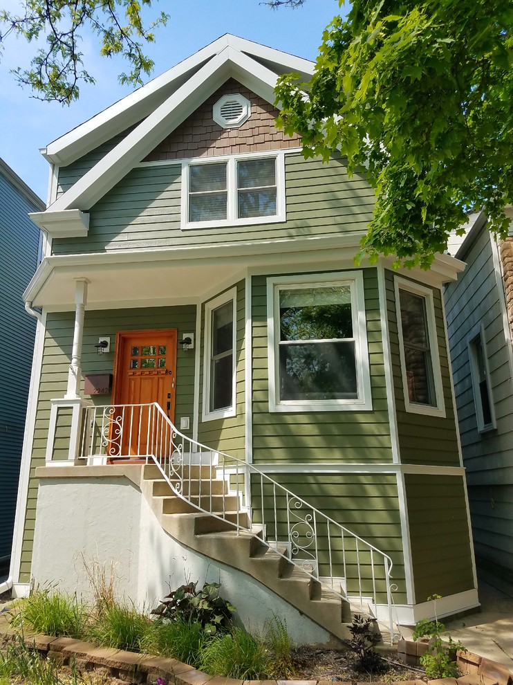 Medium sized and green victorian detached house in Chicago with three floors, concrete fibreboard cladding, a shingle roof and a pitched roof.