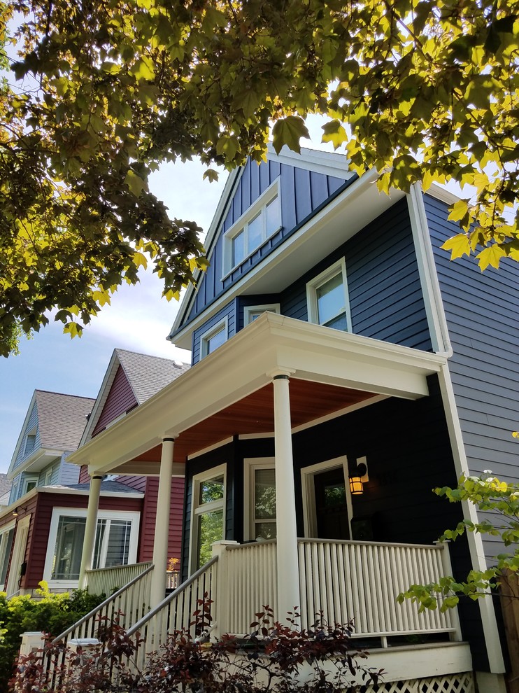 Medium sized and blue classic two floor detached house in Chicago with concrete fibreboard cladding, a mansard roof and a shingle roof.