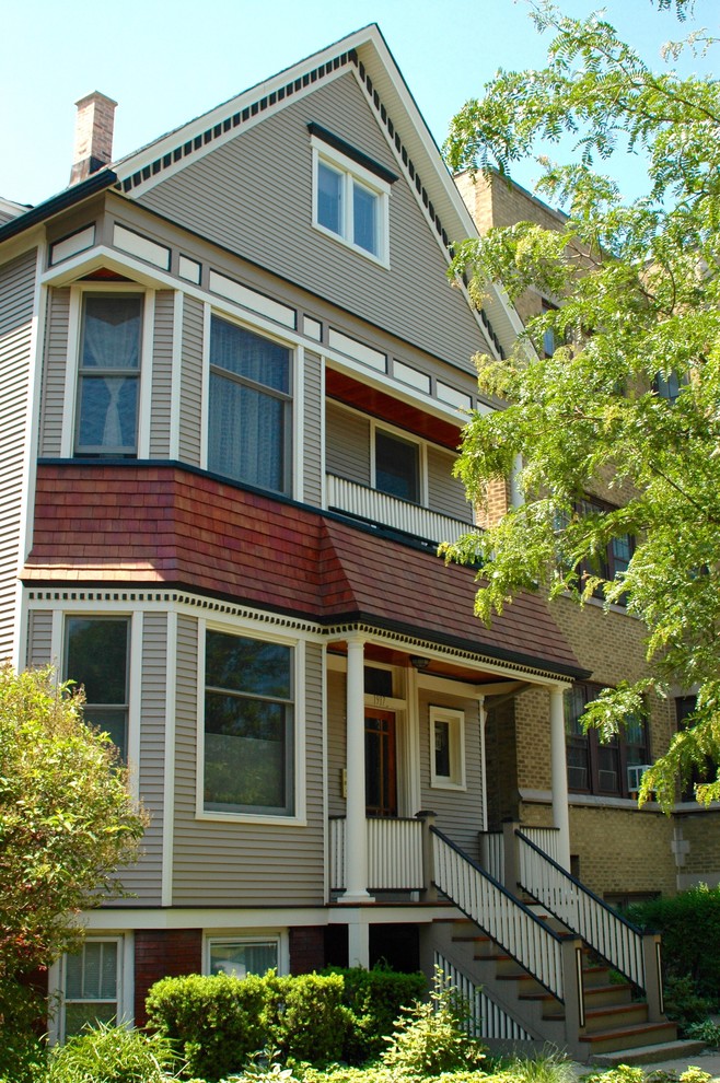 Imagen de fachada beige clásica de tamaño medio de dos plantas con revestimiento de vinilo