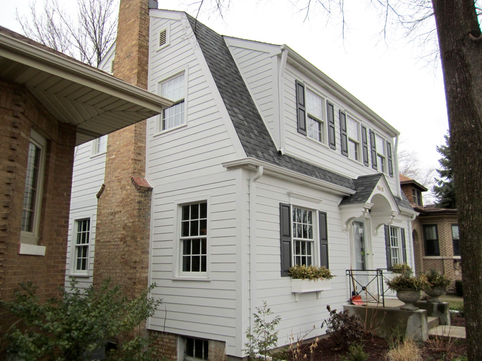 Mid-sized traditional white two-story concrete fiberboard house exterior idea in Chicago with a gambrel roof and a shingle roof