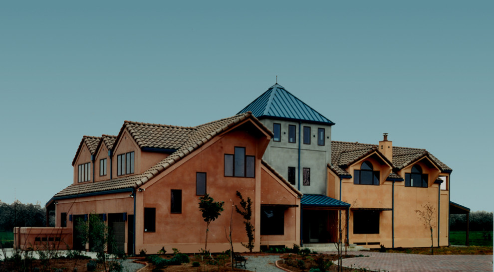 Diseño de fachada de casa multicolor contemporánea grande de tres plantas con revestimiento de estuco, tejado a dos aguas y tejado de teja de barro