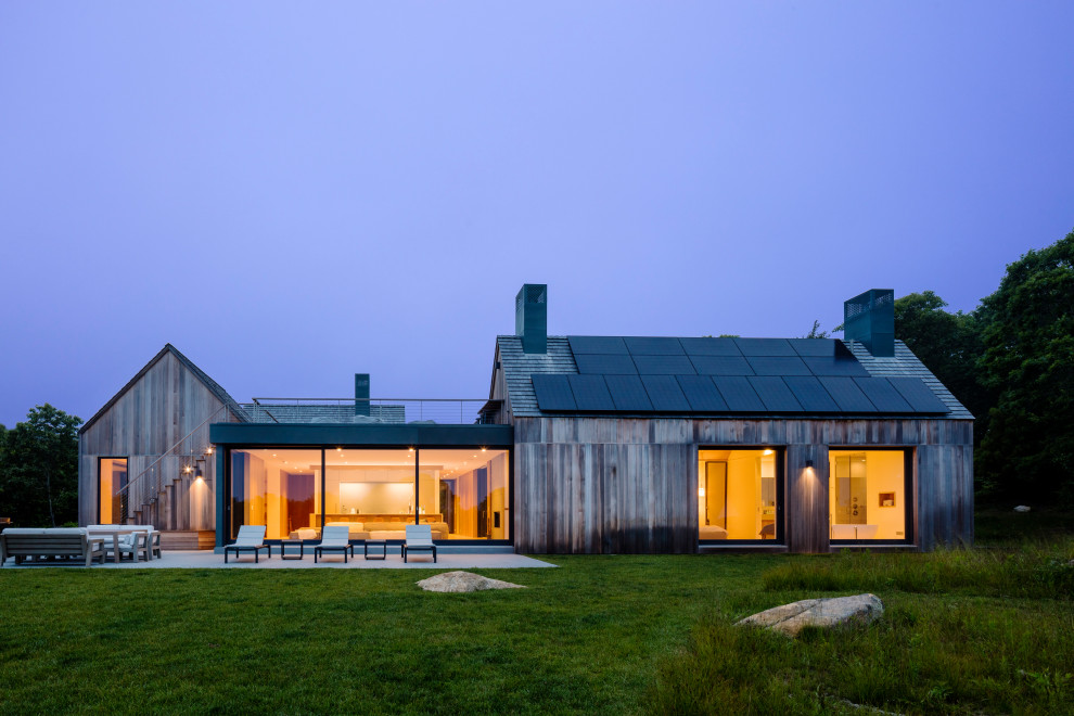 Réalisation d'une façade de maison grise design en bois à un étage avec un toit à deux pans et un toit en shingle.