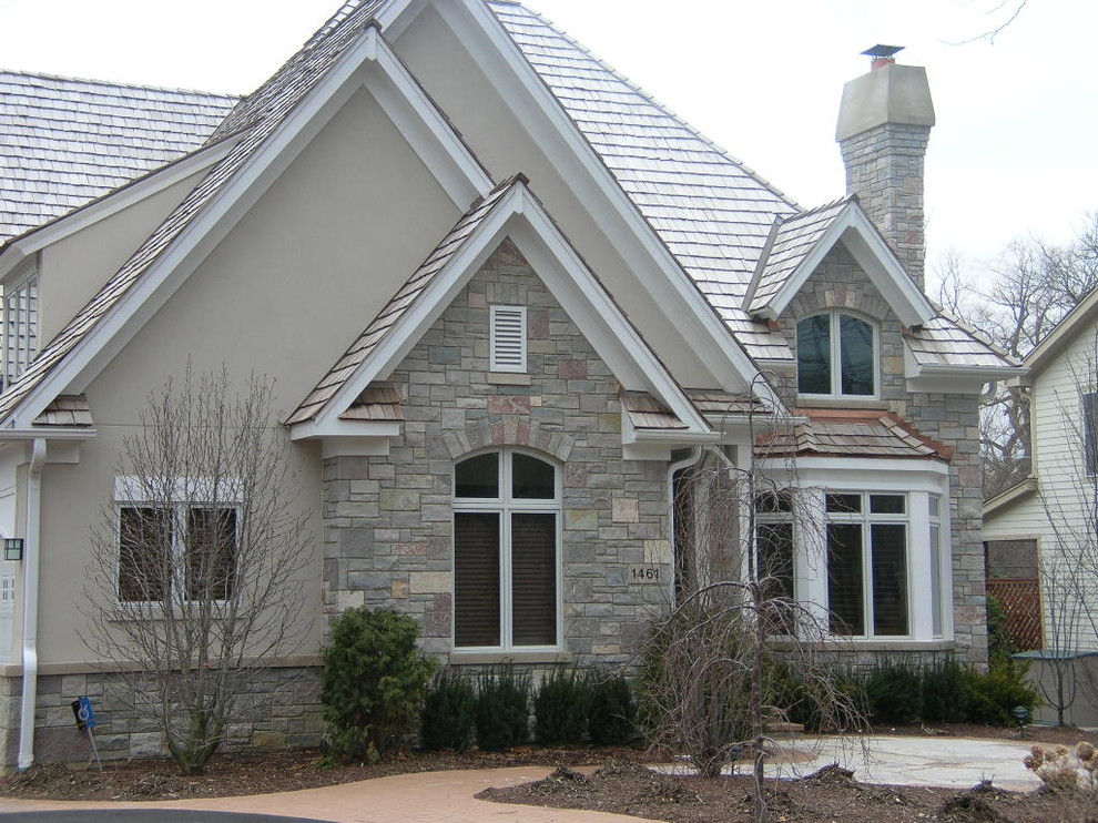 Пример оригинального дизайна: двухэтажный, бежевый дом среднего размера в стиле кантри с облицовкой из цементной штукатурки и двускатной крышей