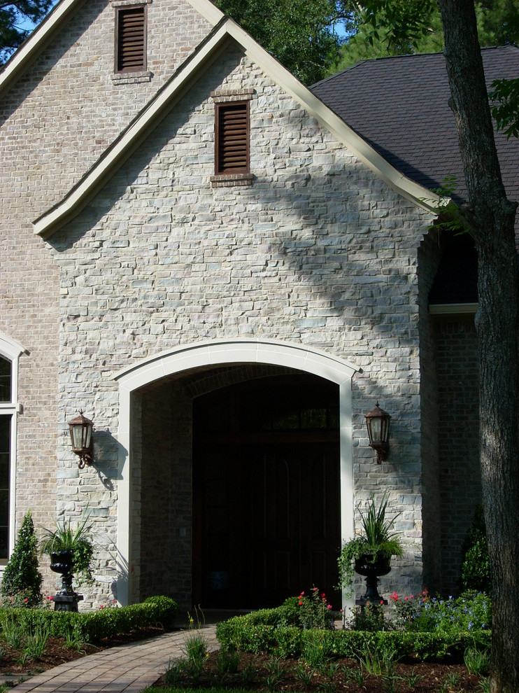Стильный дизайн: одноэтажный, коричневый дом среднего размера в классическом стиле с облицовкой из камня - последний тренд