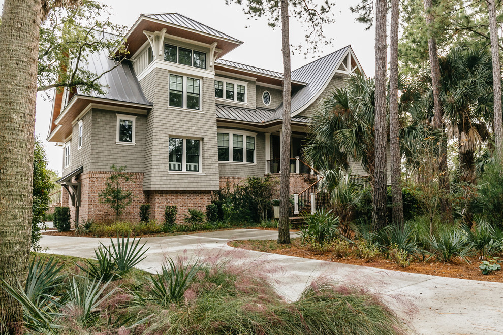 Beach style gray two-story house exterior photo in Charleston with a hip roof and a metal roof