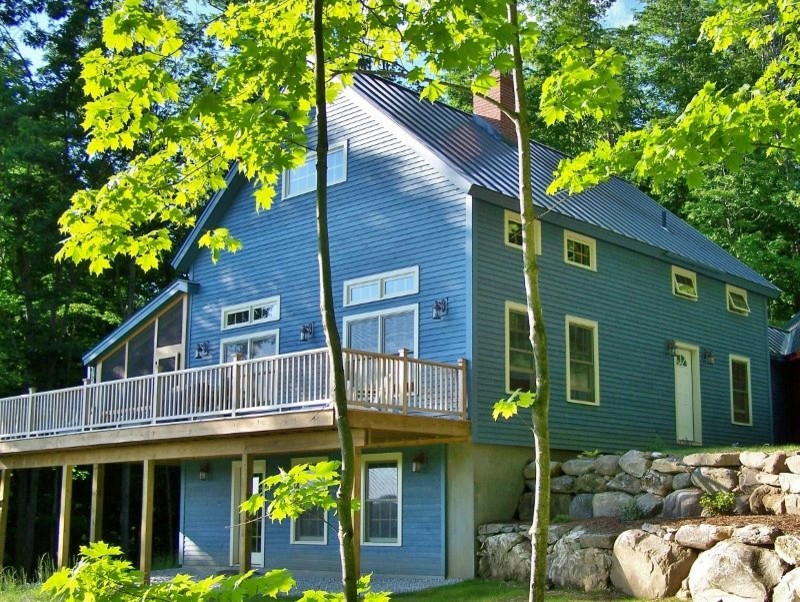 Ejemplo de fachada de casa azul clásica grande de tres plantas con revestimiento de madera y tejado a dos aguas