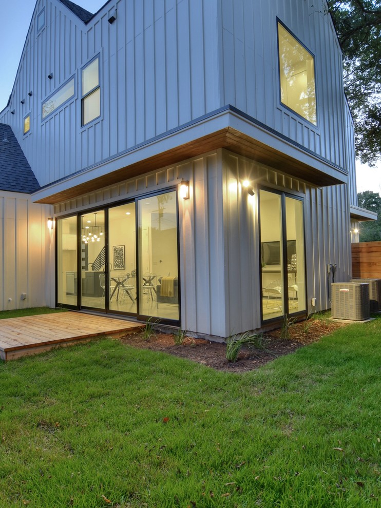 This is an example of a medium sized and white rural two floor house exterior in Austin with concrete fibreboard cladding and a pitched roof.