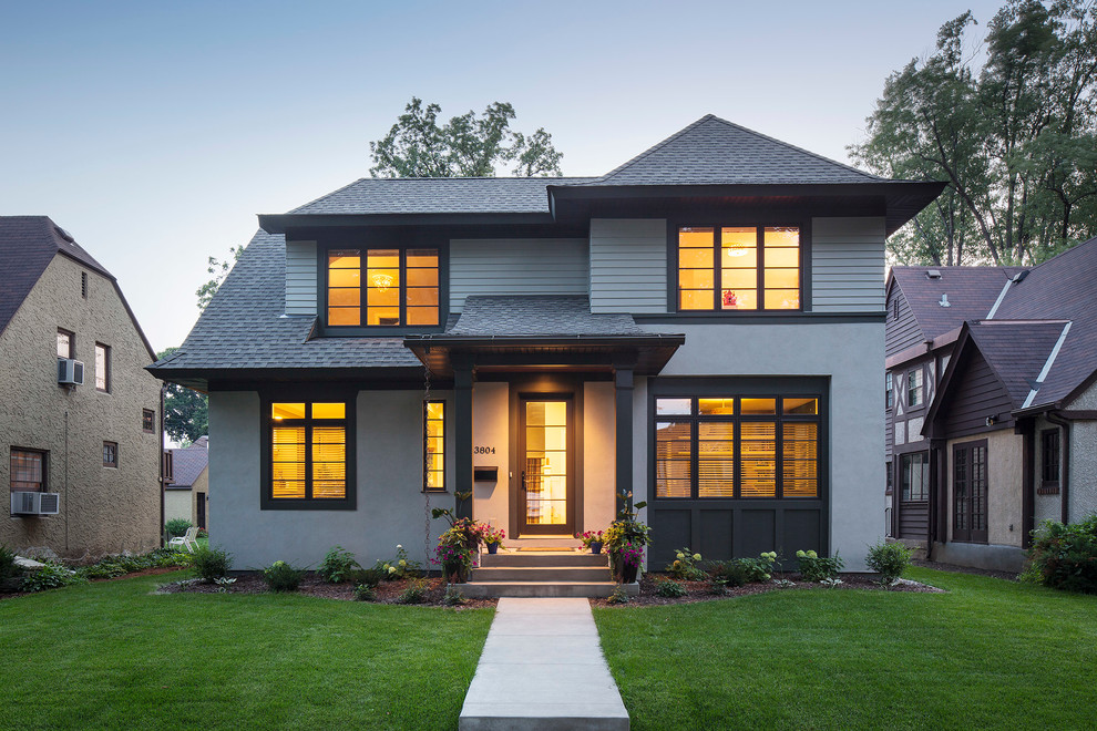 Example of a mid-sized transitional gray two-story stucco exterior home design in Minneapolis with a hip roof