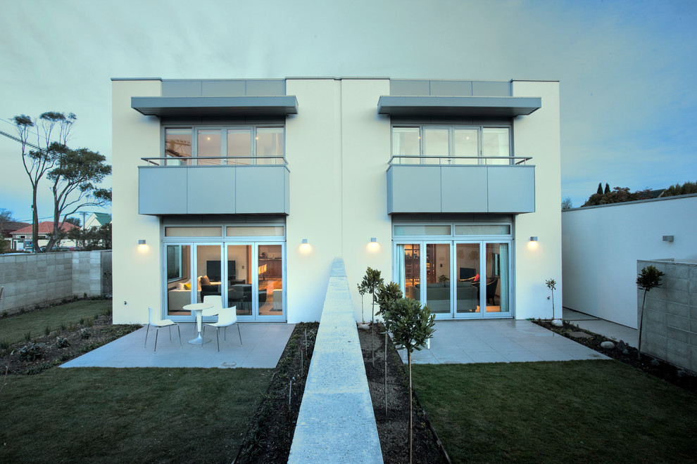 Kleine, Zweistöckige Moderne Doppelhaushälfte mit Mix-Fassade, grauer Fassadenfarbe und Flachdach in Christchurch