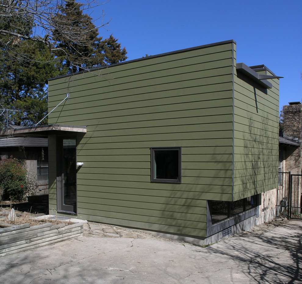 Foto della facciata di una casa piccola verde moderna a un piano con rivestimento con lastre in cemento